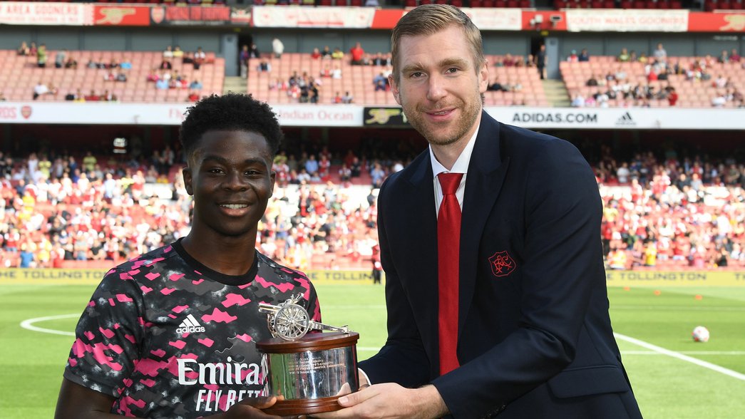 Per Mertesacker presents an award to Bukayo Saka at Emirates Stadium